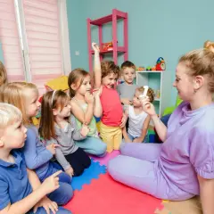 Lehrerin zeigt Kindern im Kindergarten eine Zahl. Tolle Projekte im Kindergarten Ideen für den Unterricht.