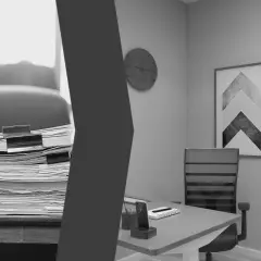 Ein überladenes Schreibtisch-Chaos trifft auf ein aufgeräumtes Arbeitszimmer Lehrer. Stapel von Akten und Ordnern links, ein moderner Schreibtisch mit Uhr und Bild rechts.