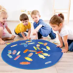 Vier Kinder spielen mit bunten Bonbon-Formen auf einer blauen Matte. Tolle Kindergarten spiele für kleine Entdecker.