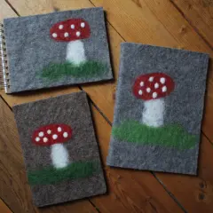 Drei Filz-Notizbücher mit Fliegenpilz-Motiven, perfekt für nassfilzen mit Kindern.