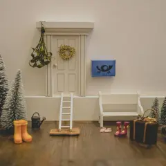 Kleine Weihnachtsbäume, eine Leiter und Stiefel vor einer Tür – tolle Wichtel Ideen für den Kindergarten, um eine winterliche Szene zu gestalten.