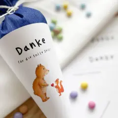 Ein liebevoll gestalteter Zuckertüte für das Kindergarten-Basteln: Ein Bär und ein Eichhörnchen mit Herz, umgeben von bunten Schokolinsen.