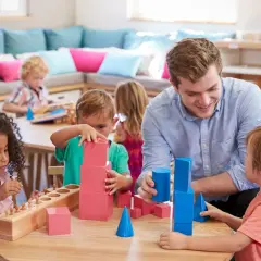 Lehrer fördert mathematische Bildung in der Kita durch spielerisches Bauen mit geometrischen Formen.