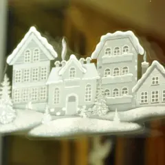 Winterliche Häuser mit Schnee bedeckt, ein Beispiel für schöne Fensterbilder basteln.