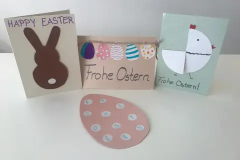 Drei selbstgebastelte Osterkarten mit Hasen, Küken und Ostereiern.