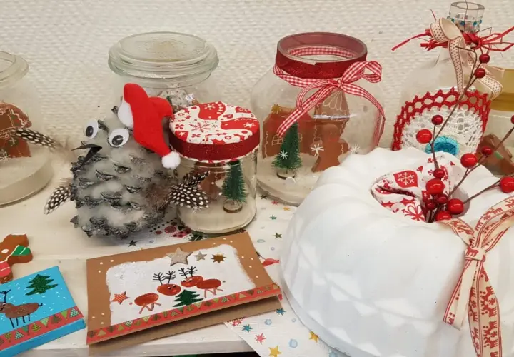 Weihnachtsbasar schule ideen: Lebkuchenmännchen in Gläsern, Tannenzapfen-Eule mit Weihnachtsmütze, Rentier-Karte und ein weißer Kuchen mit Beeren.