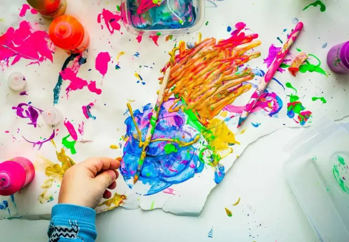 Kreative mal ideen kinder: bunte Farben, Pinsel und ein kleiner Künstler bei der Arbeit.