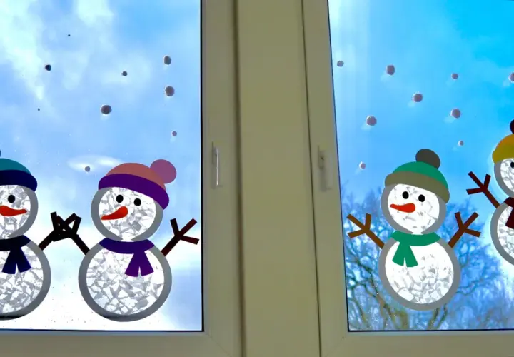 Süße Schneemann-Fensterdeko basteln mit Kindern. Vier fröhliche Schneemänner mit bunten Mützen und Schals zieren das Fenster.