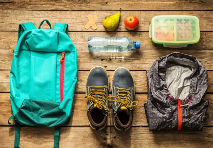 Rucksack, Schuhe, Jacke, Wasserflasche, Obst und Lunchbox – alles für die Klassenfahrt Packliste bereit.