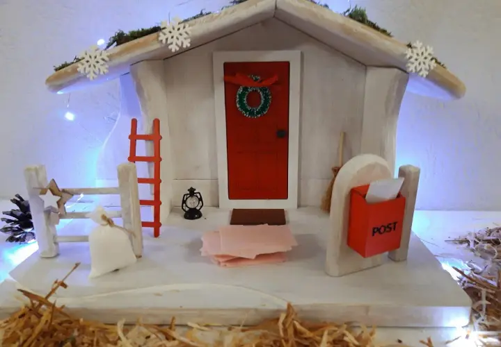 Winterliche Deko mit Weihnachtshaus, Schneeflocken und Lichterkette. Perfekt für Kita-Angebote im Winter.