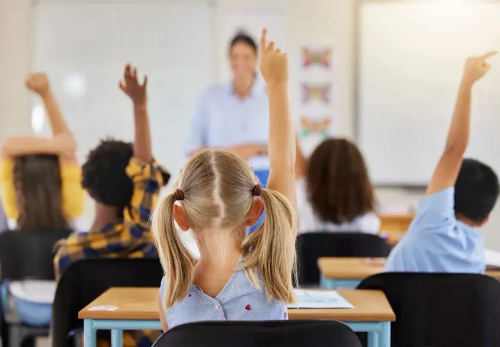 Kinder melden sich im Unterricht, um Fragen zu beantworten. Ein guter Start in der neuen Schule!