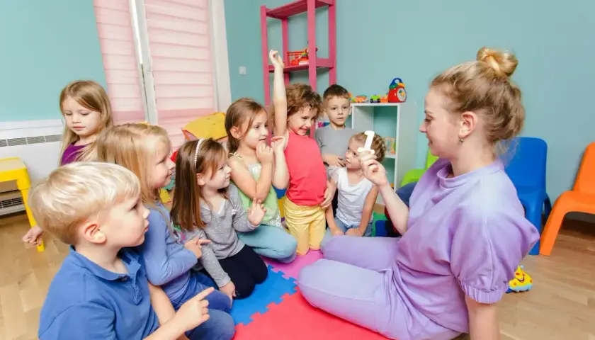 Lehrerin zeigt Kindern im Kindergarten eine Zahl. Tolle Projekte im Kindergarten Ideen für den Unterricht.