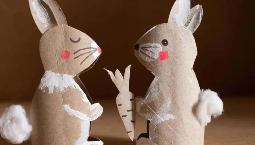 Zwei selbstgebastelte Osterhasen aus Pappe, einer mit Karotte, perfekt für osterhase basteln kinder.