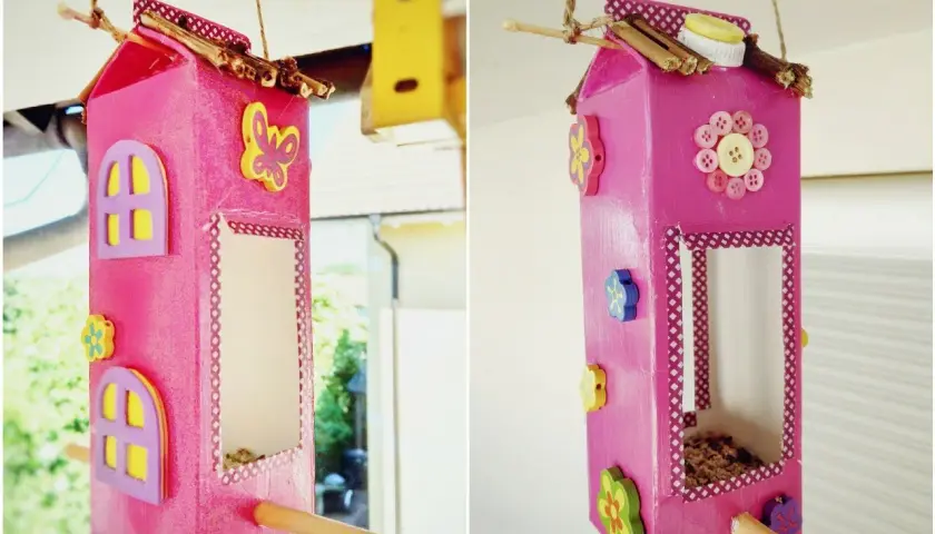 Selbstgebaute Vogelfutterstation aus Milchkarton, dekoriert mit Knöpfen und Holzblumen. Ein tolles Projekt zum vogelfutterstation selber bauen mit kindern.