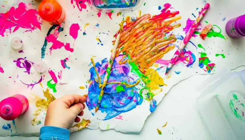 Kreative mal ideen kinder: bunte Farben, Pinsel und ein kleiner Künstler bei der Arbeit.
