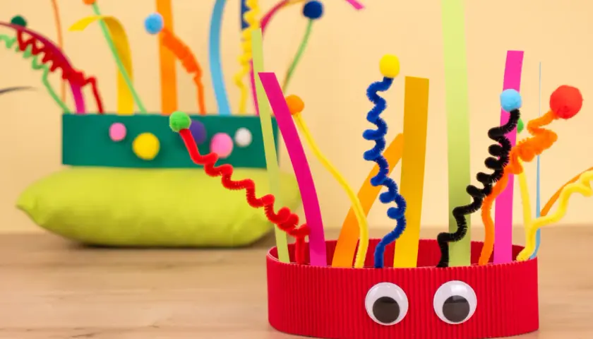 Bunte Faschingskrone, gebastelt mit Pfeifenreinigern und Papierstreifen. Ein lustiges Bastelprojekt für die Krippe.