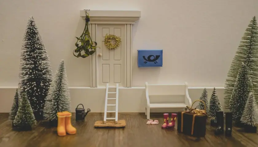 Kleine Weihnachtsbäume, eine Leiter und Stiefel vor einer Tür – tolle Wichtel Ideen für den Kindergarten, um eine winterliche Szene zu gestalten.