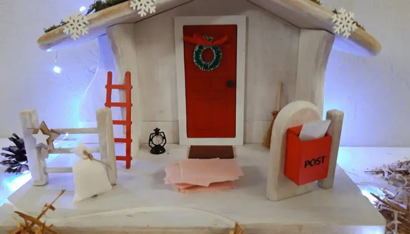 Winterliche Deko mit Weihnachtshaus, Schneeflocken und Lichterkette. Perfekt für Kita-Angebote im Winter.