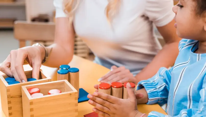Ein Kind mit Autismus lernt spielerisch mit Holzbausteinen. Ein Test zur Förderung der Feinmotorik und kognitiven Fähigkeiten.