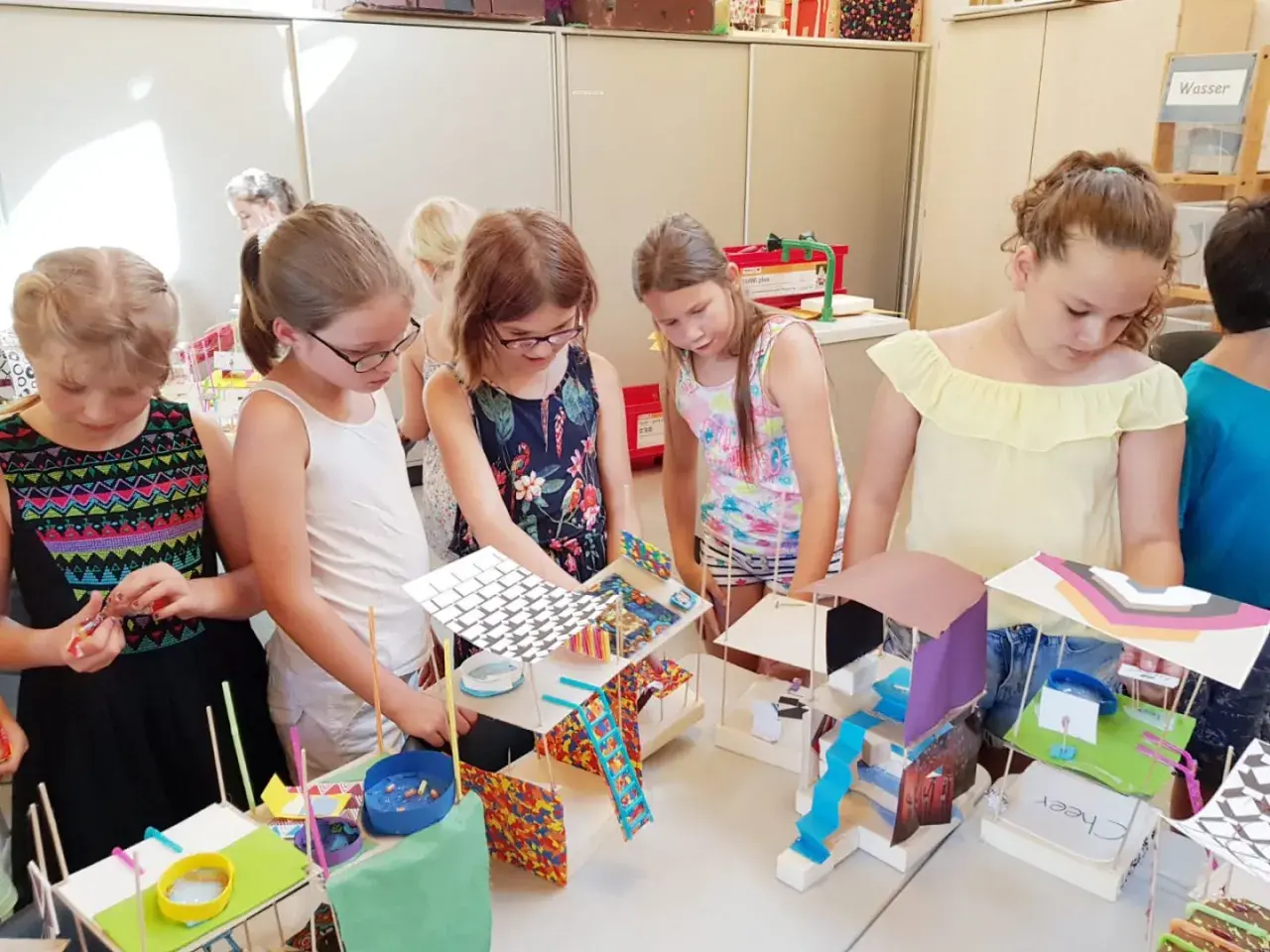 Kinder bauen fantasievolle Häuser mit Alltagsmaterialien im Kindergarten. Kreativität und Spaß beim Basteln.