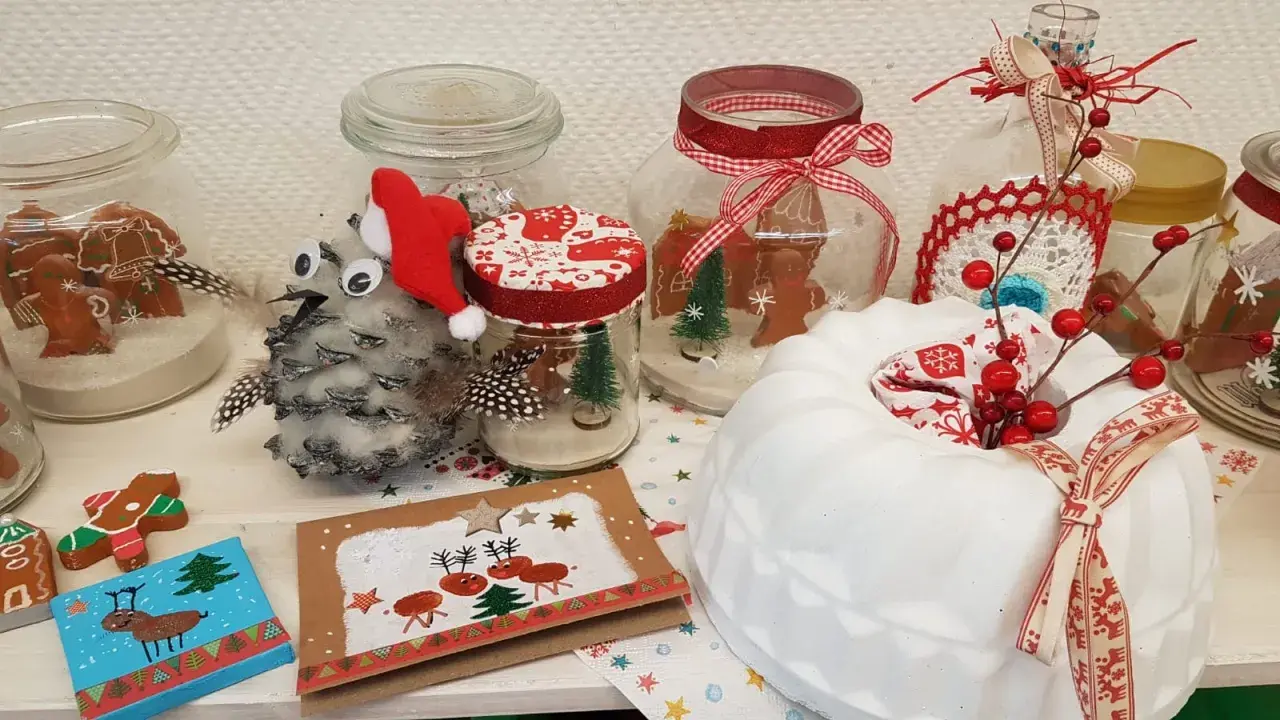 Weihnachtsbasar schule ideen: Lebkuchenmännchen in Gläsern, Tannenzapfen-Eule mit Weihnachtsmütze, Rentier-Karte und ein weißer Kuchen mit Beeren.
