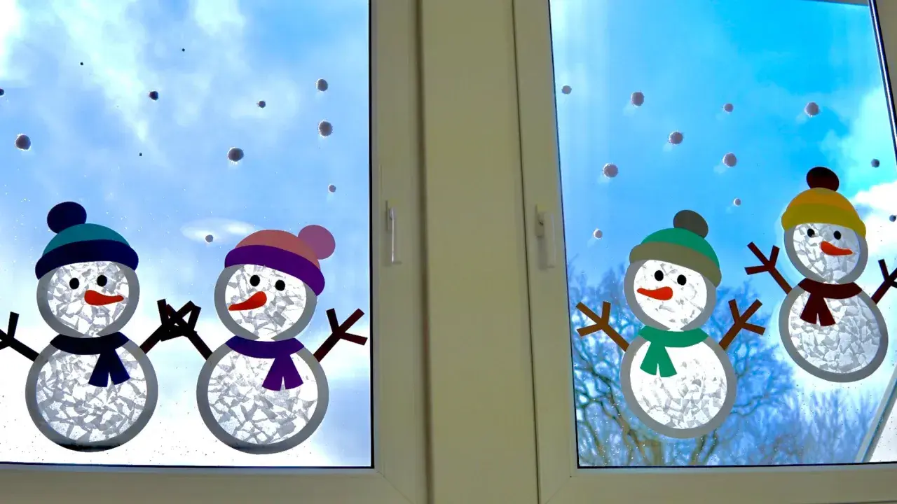 Süße Schneemann-Fensterdeko basteln mit Kindern. Vier fröhliche Schneemänner mit bunten Mützen und Schals zieren das Fenster.