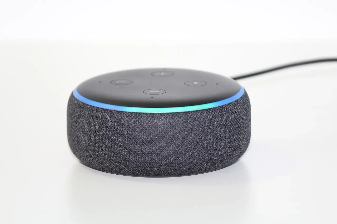Ein grauer Echo Dot mit leuchtendem Ring, bereit, Alexa Skills zu aktivieren und dein Zuhause zu steuern.