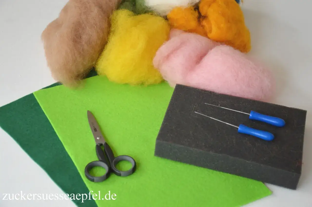 Bunte Wolle, Filznadeln, Schere und Filzplatten liegen bereit f&uuml;r kreatives trockenfilzen mit Kindern.