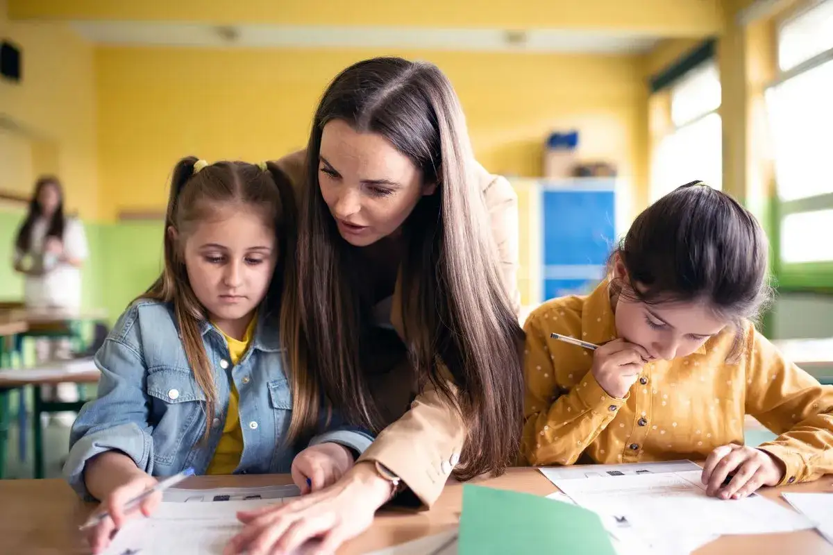 Lehrerin hilft M&auml;dchen mit Lernschwierigkeiten, die Lernbehinderung Symptome zeigen.