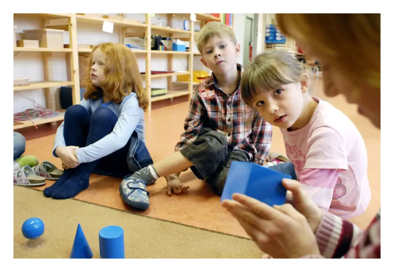 Kinder lernen in einer Montessori schule spielerisch geometrische Formen.