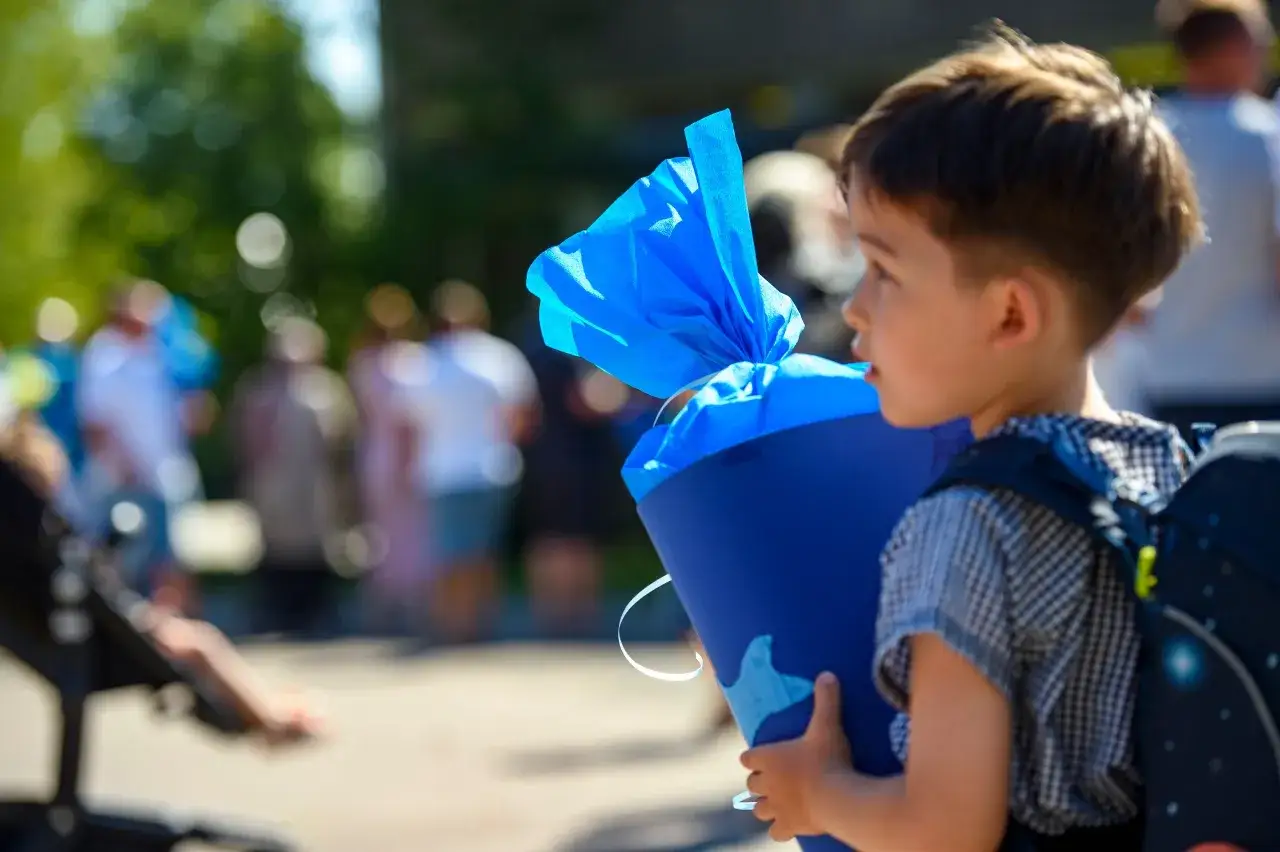Kleiner Junge mit Schult&uuml;te und Rucksack, bereit f&uuml;r einen guten Start in der neuen Schule.