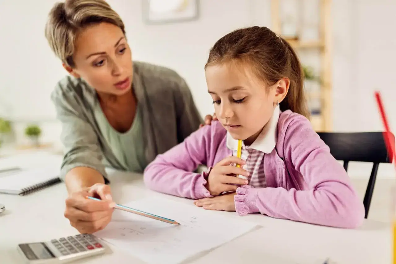 Lehrerin erkl&auml;rt einem M&auml;dchen Mathe. Die schlechten Noten wegen Faulheit sind ein ernstes Thema.