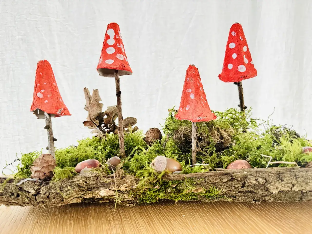 Kreative Projekte Grundschule: Fliegenpilze aus Eierkartons auf Moos und Holz, ein Wald-Diorama.