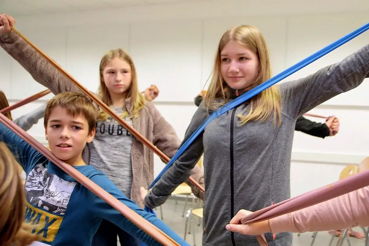Kinder &uuml;ben mit bunten B&auml;ndern, eine spielerische Art, lernen mit spass zu verbinden.