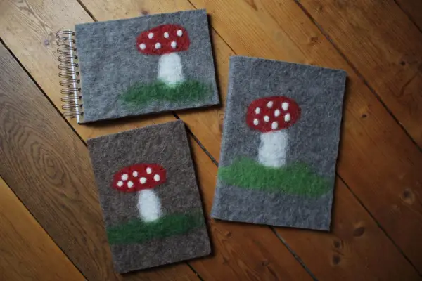 Drei Filz-Notizbücher mit Fliegenpilz-Motiven, perfekt für nassfilzen mit Kindern.